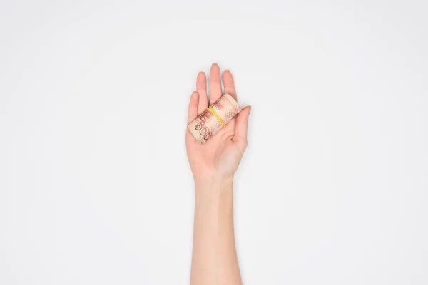 Partial view of woman holding money roll in open palm isolated on grey — Stock Photo