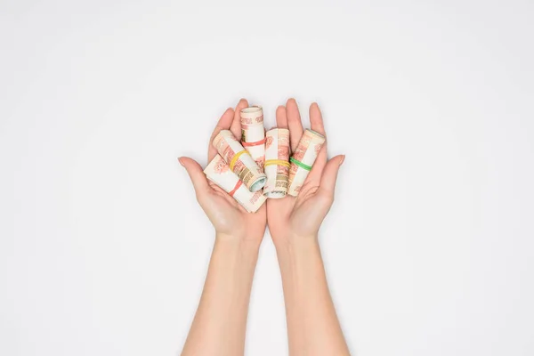 Partial view of woman holding money rolls in open palms isolated on grey — Stock Photo