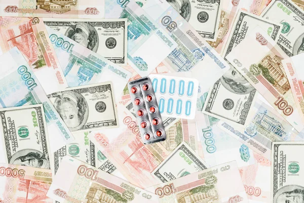 Top view of pills on rubles and dollars background — Stock Photo