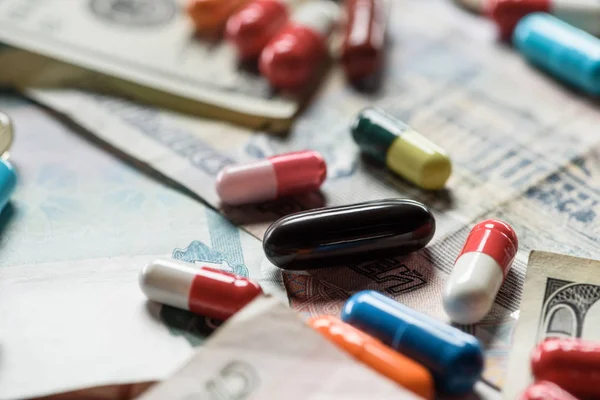 Selektive Fokussierung der verschiedenen Pillen auf den Bargeldhintergrund — Stockfoto