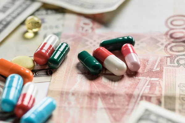 Selective focus of different pills on money background — Stock Photo