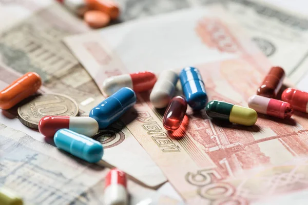 Selective focus of colorful pills on banknotes background — Stock Photo
