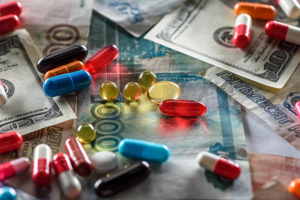 Nahaufnahme heller Pillen unterschiedlicher Form auf Bargeldhintergrund — Stockfoto