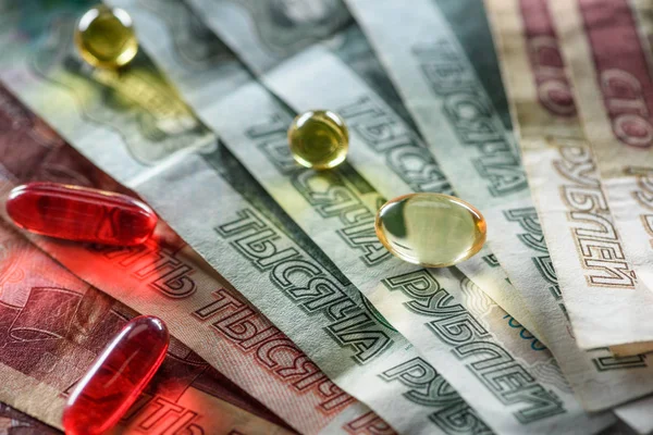 Close up of red oval and yellow round pills on cash background — Stock Photo