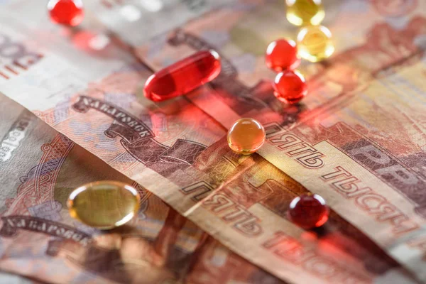 Close up of shiny oval and round pills on rubles background — Stock Photo
