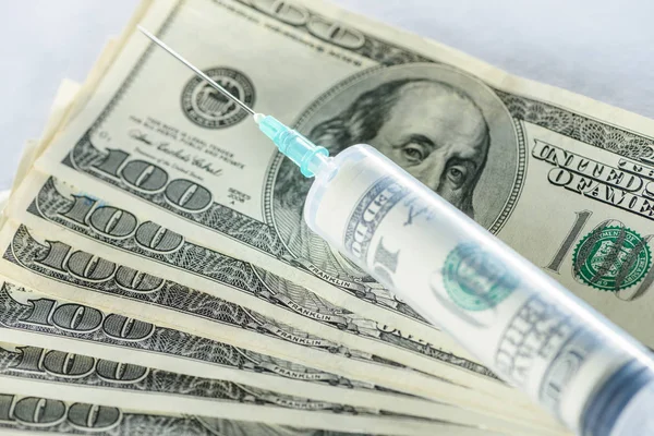 Close up of syringe with money injection on dollar banknotes — Stock Photo