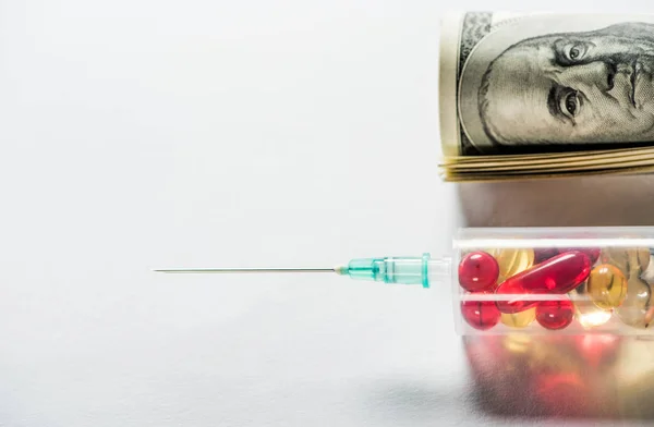 Gros plan de la seringue avec des médicaments près du rouleau d'argent sur fond gris — Photo de stock
