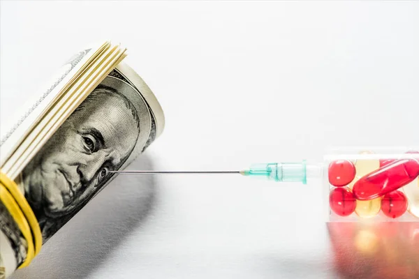 Primo piano della siringa con pillole vicino al rotolo di denaro su sfondo bianco — Foto stock