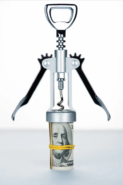 Corkscrew with money roll on blurred white and grey background — Stock Photo