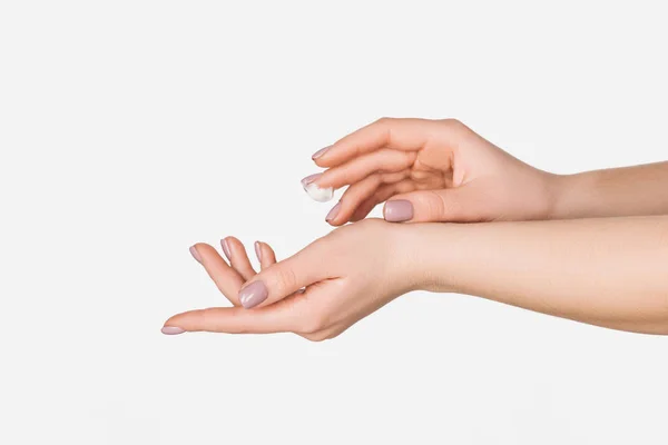 Partial view of woman applying moisturizing hand cream isolated on white — Stock Photo