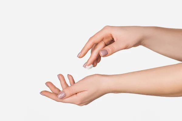 Abgeschnittene Ansicht einer Frau, die feuchtigkeitsspendende Handcreme isoliert auf Weiß mit Kopierraum aufträgt — Stockfoto