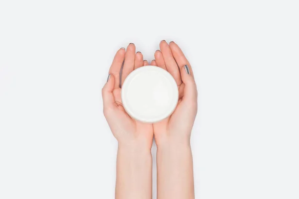 Vista superior de la mujer sosteniendo crema de manos aislada en blanco - foto de stock