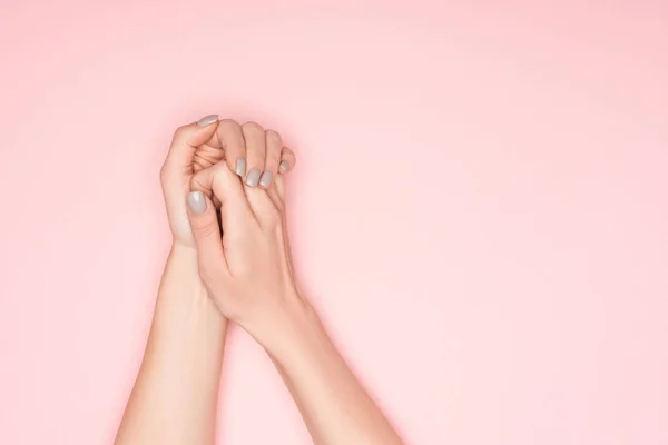 Vista recortada de las manos femeninas plegadas aisladas en rosa - foto de stock