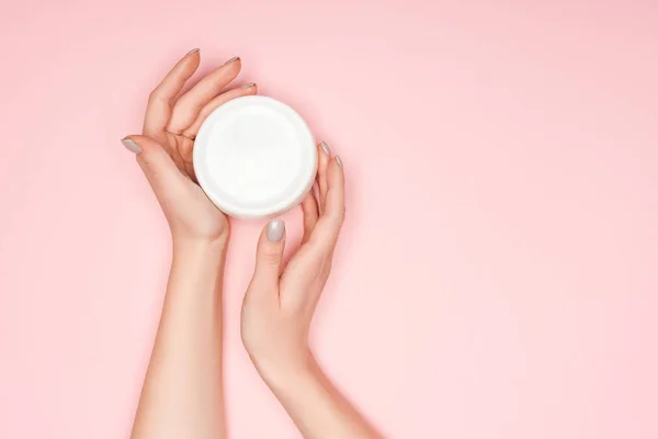 Cropped of view of female hands with body cream isolated on pink with copy space — Stock Photo