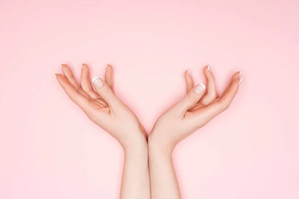 Vista recortada de las manos femeninas aisladas en rosa - foto de stock
