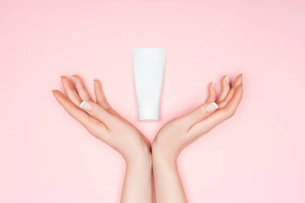 Cropped view of female hands with hand cream isolated on pink — Stock Photo