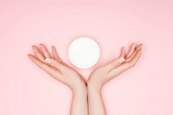 Vue recadrée des mains féminines avec crème corporelle isolée sur rose — Photo de stock