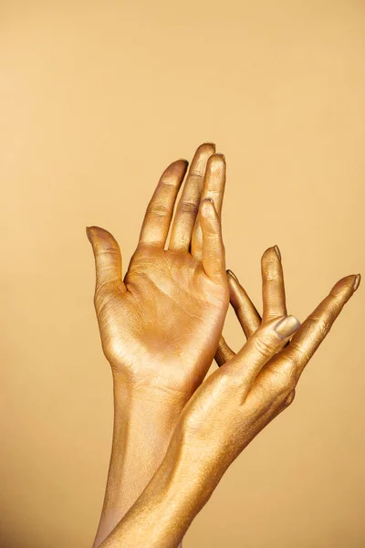 Vista parziale di mani dipinte femminili isolate su oro — Foto stock