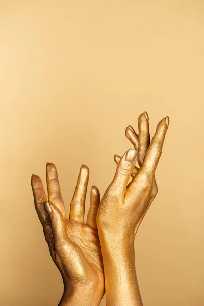 Cropped view of female painted hands on golden background — Stock Photo