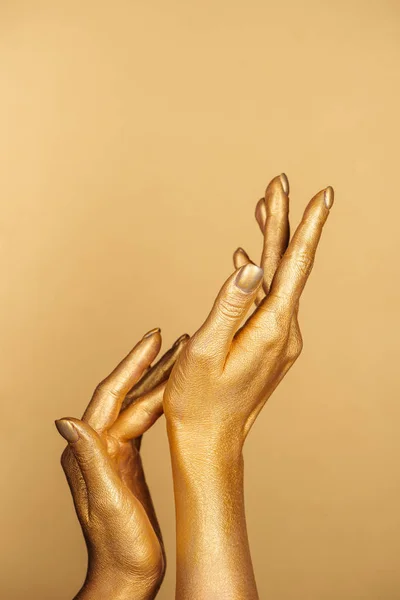 Vue partielle des mains peintes féminines sur fond doré — Photo de stock