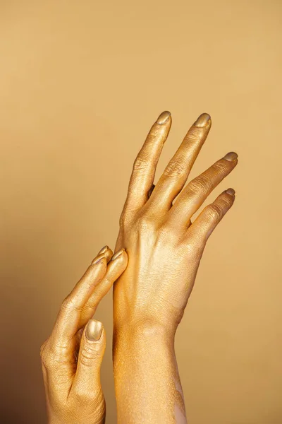 Cropped view of female painted hands on golden background — Stock Photo