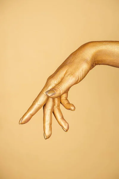 Vista recortada de la mano pintada femenina aislada en oro - foto de stock