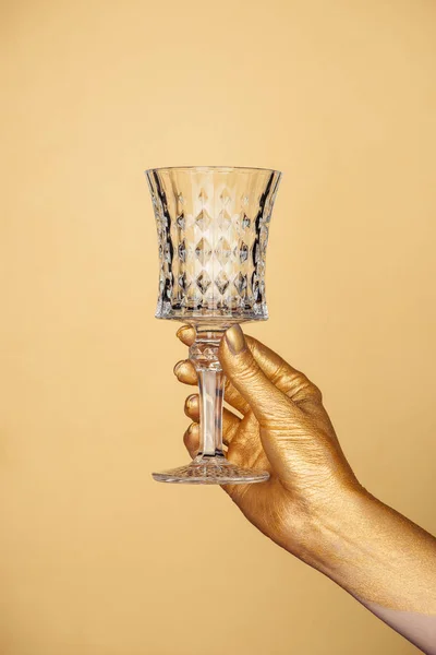 Vista recortada de la mano pintada femenina con vidrio vintage aislado en oro - foto de stock