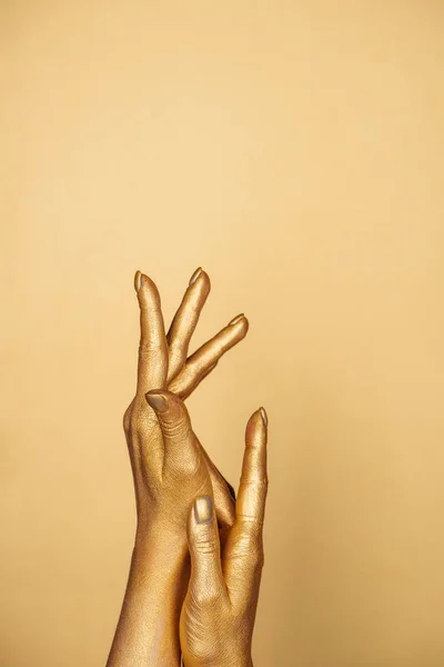 Partial view of female painted hands isolated on gold — Stock Photo