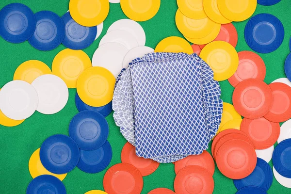 Top view of green poker table with colorful chips and playing cards — Stock Photo