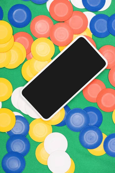 Vista dall'alto del tavolo da poker verde con chip multicolore e smartphone — Foto stock