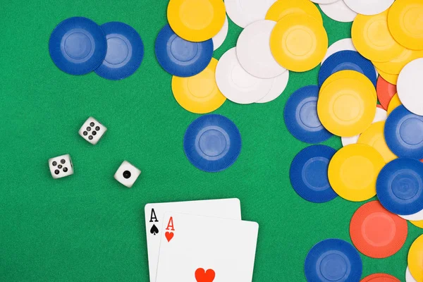 Draufsicht auf den grünen Pokertisch mit bunten Chips, Würfeln und zwei aufgeklappten Asen — Stockfoto