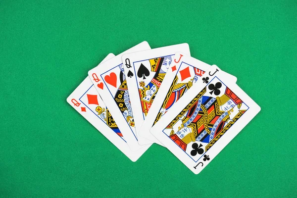 Vista superior de la mesa de póquer verde con cartas desplegadas, tres reinas y dos gatos - foto de stock