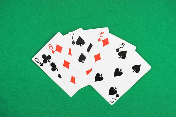 Vista superior de la mesa de póquer verde y cartas desplegadas con diferentes palos - foto de stock