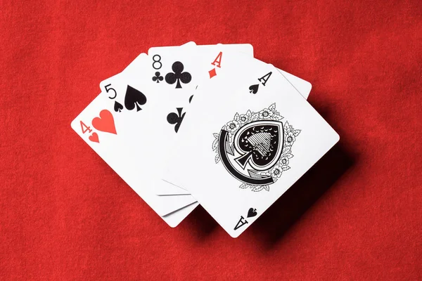 Верхний вид красного стола и комбинация игральных карт с различными мастями — стоковое фото