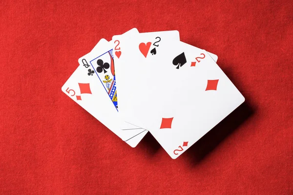 Top view of red poker table and playing cards combination with different suits — Stock Photo