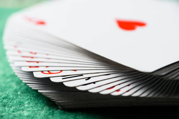 Селективный фокус развернутых игральных карт на зеленом столе — стоковое фото