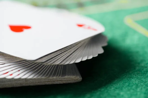 Enfoque selectivo de jugar a las cartas en baraja en la mesa de póquer verde - foto de stock