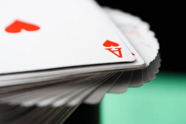 Selective focus of ace playing card with hearts suit in deck on green background — Stock Photo