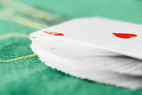 Enfoque selectivo de cartas desplegadas en la baraja en la mesa de póquer verde - foto de stock