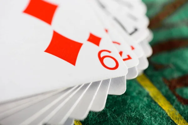 Selective focus of playing card with diamonds suit in deck on green poker table — Stock Photo