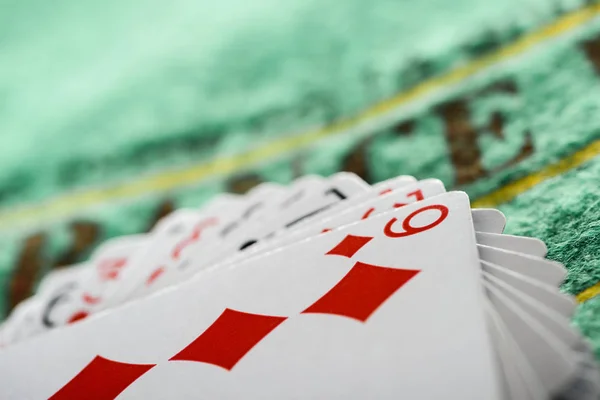 Selective focus of playing card with diamonds suit in deck on green table — Stock Photo