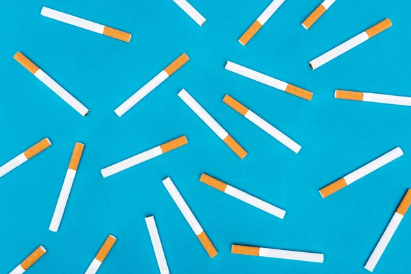 Flat lay of cigarettes isolated on blue — Stock Photo