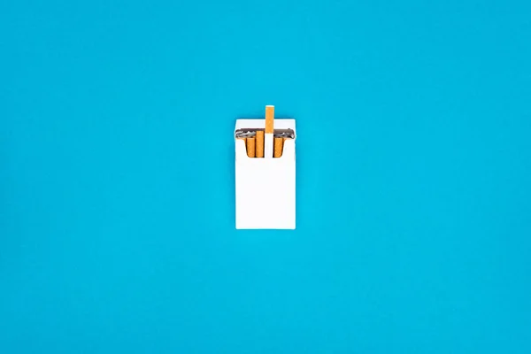 Vue du dessus du paquet de cigarettes blanc isolé sur bleu — Photo de stock