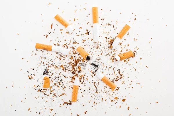 Студійний знімок сигаретних прикладів і тютюну ізольовано на білому фоні, концепція припинення куріння — стокове фото