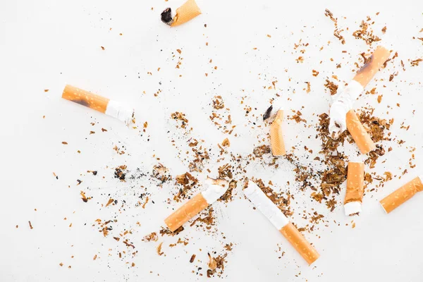 Blick von oben auf kaputte Zigaretten isoliert auf weiß, Rauchen aufhören Konzept — Stockfoto