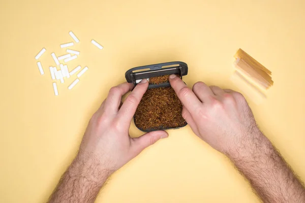 Vista parcial del hombre con caja de tabaco aislada en amarillo — Stock Photo