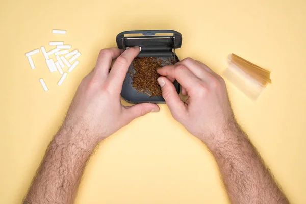 Vista recortada del hombre usando caja de tabaco aislada en amarillo — Stock Photo