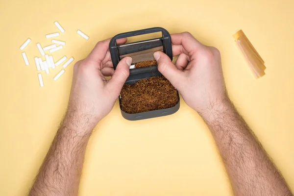 Vista parcial do homem segurando snuffbox em mãos isoladas em amarelo — Fotografia de Stock