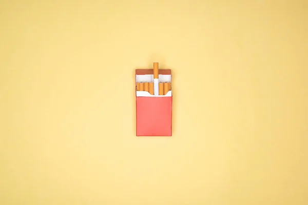 Studio shot of red pack of cigarettes isolated on yellow — Stock Photo