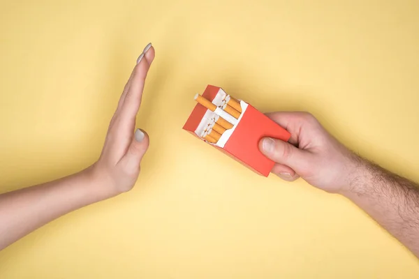 Vue recadrée de la jeune femme refuse les cigarettes isolées sur jaune, arrêter de fumer concept — Photo de stock